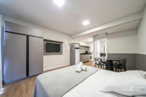 ボンバスにある509- Suite no Villa Francione Bombasの大きな白いベッドとキッチンのある寝室