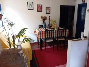 a dining room with a table and chairs with a table and a table at Quarto Britney in Ouro Preto