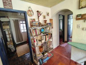 a room with a book shelf filled with books at Quarto Britney in Ouro Preto