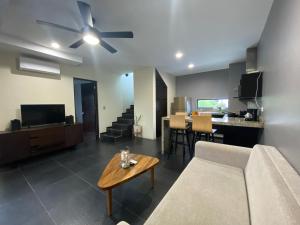 Una sala de estar con un sofá y un ventilador de techo. en Sole Suites, en Playa del Carmen