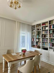 a dining room with a wooden table and bookshelves at Villa Mare in Gdańsk