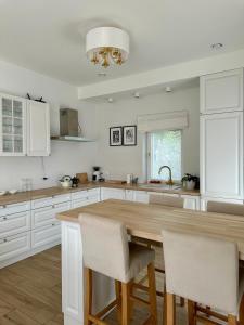 a kitchen with a wooden table and white cabinets at Villa Mare in Gdańsk