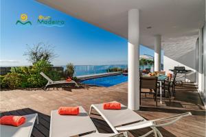 una villa con piscina e patio con sedie e tavolo di OurMadeira - Fonte do Mar 1, premium a Caniço