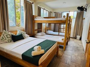 Ce lit se trouve dans un dortoir doté de 2 lits superposés et de fenêtres. dans l'établissement Merakai Hostel Rincon del Mar, à Rincón