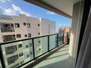 een balkon met uitzicht op een gebouw bij Edificio Liv P.Verde Apto 1013-Mandi Hospitalidade in Maceió