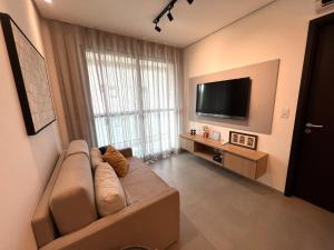 een woonkamer met een bank en een flatscreen-tv bij Edificio Liv P.Verde Apto 1013-Mandi Hospitalidade in Maceió