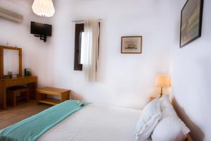 a bedroom with a white bed and a desk at Thalassia Studios in Kalamitsa