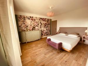 a bedroom with a bed and a wall with flowers at Mas Belvega in La Baume-de-Transit