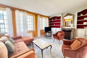 a living room with a couch and chairs and a fireplace at Refuge breton entre mer pierres et jardin in Port-Louis