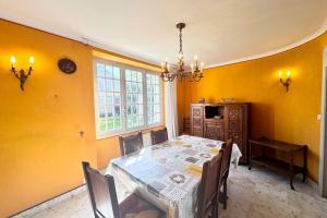 a dining room with a table and yellow walls at Refuge breton entre mer pierres et jardin in Port-Louis