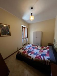 SantʼAnatolia di NarcoにあるDelizioso appartamento nel borgoのベッドルーム1室(カラフルなキルトのベッド1台付)