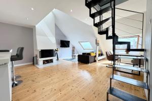 ein Wohnzimmer mit einer Wendeltreppe und einem Kamin in der Unterkunft Loft contemporain - En plein centre de Lorient in Lorient