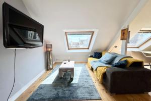 ein Wohnzimmer mit Couch und Flachbildfernseher in der Unterkunft Loft contemporain - En plein centre de Lorient in Lorient