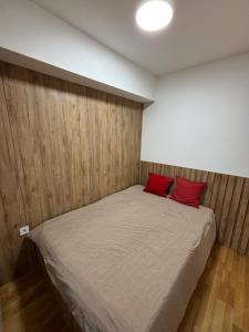 a bedroom with a bed with red pillows on it at City Center Apartment 2 in Skopje