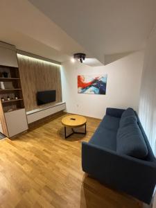 a living room with a blue couch and a table at City Center Apartment 2 in Skopje