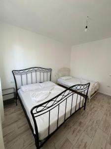 a bedroom with two beds with white sheets at Casa Del Mar in Shëngjin