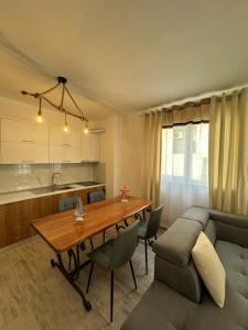a kitchen and dining room with a table and a couch at Casa Del Mar in Shëngjin +3 photos