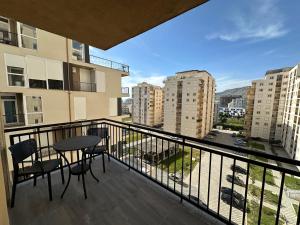 a balcony with a table and chairs and buildings at Casa Del Mar in Shëngjin