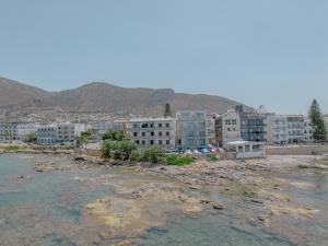 a group of buildings next to a body of water at Eclectic Vintage Apartment- Sea View Perfection, Hersonissos, Crete in Limín Khersonísou