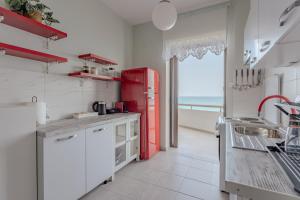 a kitchen with a red refrigerator and a view of the ocean at Eclectic Vintage Apartment- Sea View Perfection, Hersonissos, Crete in Limín Khersonísou