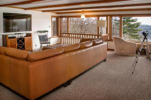 a large brown couch in a living room with a television at Keuka Sunrise 