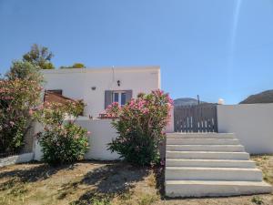 a white house with stairs and flowers at Manos' Dream in Empourios