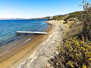 a bench sitting on a beach next to the water at Manos' Dream in Empourios