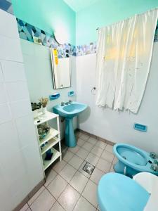 ein Badezimmer mit einem blauen WC und einem Waschbecken in der Unterkunft Casa Quinta Villa Anita in San Pedro