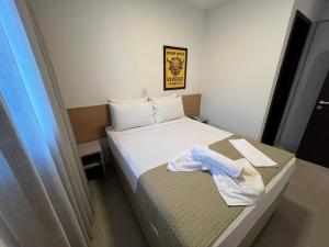 een hotelkamer met een bed met een handdoek erop bij Edificio Liv P.Verde Apto 1013-Mandi Hospitalidade in Maceió +14 foto's