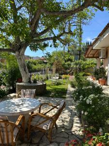 a patio with a table and chairs under a tree at Mina's serene garden house in Kontokali