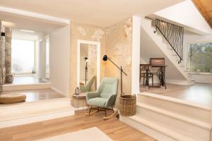 ein Wohnzimmer mit einem Stuhl und einer Treppe in der Unterkunft Accommodation TRI MURVE in Plomin