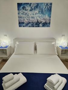 a bedroom with a white bed with towels on it at Albatros B&B Porto Cesareo in Porto Cesareo