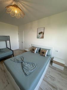 a bedroom with a large blue bed with a chandelier at Casa Del Mar 2 in Shëngjin