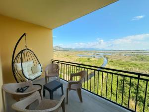 a room with a balcony with chairs and a swing at Casa Del Mar 2 in Shëngjin