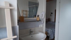 a bathroom with a sink and a mirror and a bed at Casa Flory Anna in San Lorenzo