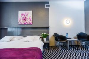 a hotel room with a bed and a table and chairs at Hotel Wyspiański in Krakow