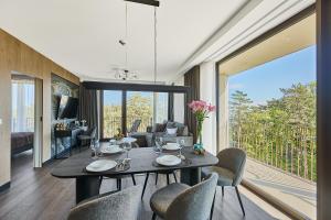 a dining room with a table and chairs and a living room at Golden Hour Apartments- Loft H 418 in Świnoujście