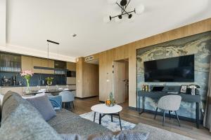 a living room with a couch and a tv at Golden Hour Apartments- Loft H 418 in Świnoujście +8 photos