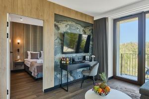 a room with a bed and a desk with a television at Golden Hour Apartments- Loft H 418 in Świnoujście