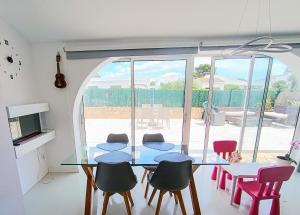 a dining room with a glass table and chairs at CHALET CALAFAT in Calafat