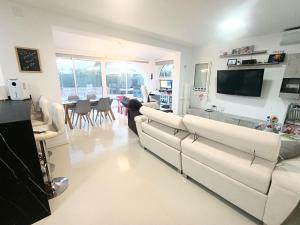 a living room with white couches and a tv at CHALET CALAFAT in Calafat