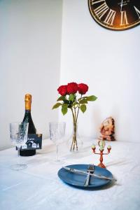 a table with a plate and wine glasses and a clock at Studio proche de Disneyland Paris in Bussy-Saint-Georges +23 photos