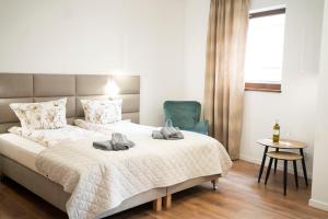 ein Schlafzimmer mit einem Bett und einem blauen Stuhl in der Unterkunft Willa Matejki - Apartament 7 in Przemyśl