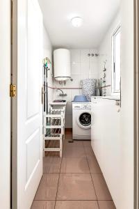 a small white kitchen with a washer and dryer at El Veril del Duque Apartment in Adeje