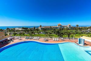 a large swimming pool with a view of the ocean at El Veril del Duque Apartment in Adeje