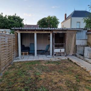 un cortile con un capanno con un divano al suo interno di Maison cosy avec Balnéo & jardin a Chalons en Champagne