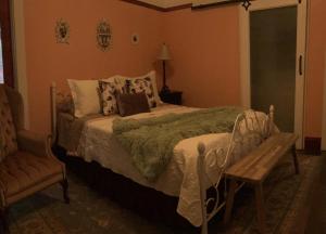 a bedroom with a bed and a wooden bench at IreneHouse Victorian INN in Sacramento
