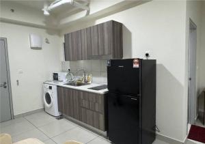 a kitchen with a black refrigerator and a dishwasher at Khan's stay in Cyberjaya