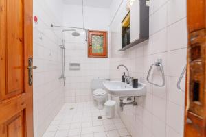 a white bathroom with a sink and a toilet at Lyria Hotel Apartments in Stalos +77 photos