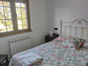 a bedroom with a bed and two windows at Casa de Aldea Misiego Rodiles in Selorio